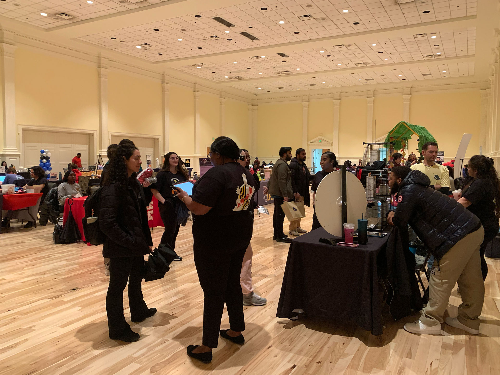 group of students engaging with different property representatives and tables during the fair